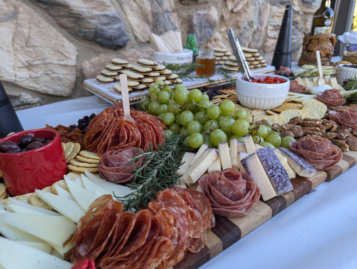 A large charcuterie grazing board for 50 people setup at a winery.